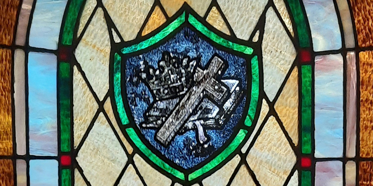 Detail of a stained glass window showing a cross, crown and Bible. Window is at Forest Park Methodist Church, Beaumont.