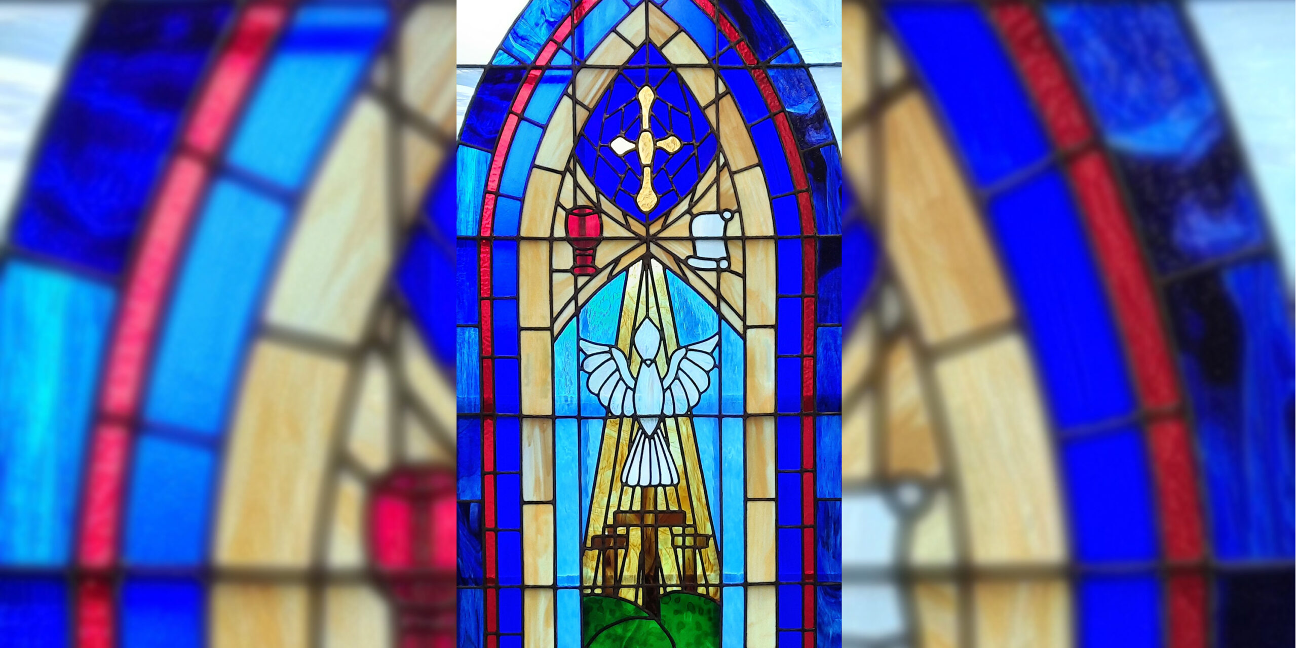 Photo of a stained glass window at China Methodist church. The window portrays a rising dove above three empty crosses.